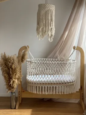 Culla in macramé in cotone naturale, intrecciata a mano con supporto in legno, stile boho, ideale per la cameretta del neonato.