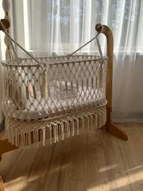Culla in macramé in cotone naturale, intrecciata a mano con supporto in legno, stile boho, ideale per la cameretta del neonato.