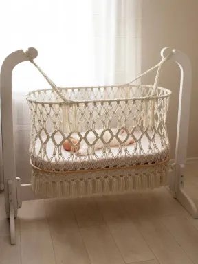 Makramee-Babywiege aus natürlicher Baumwolle, handgeknüpft mit Holzgestell, Boho-Stil, ideal für das Babyzimmer.