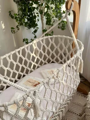 Makramee-Babywiege aus natürlicher Baumwolle, handgeknüpft mit Holzgestell, Boho-Stil, ideal für das Babyzimmer.